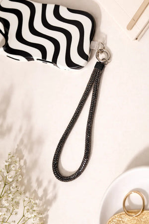 Black Charm attached to the phone cover which is full of diamonds 